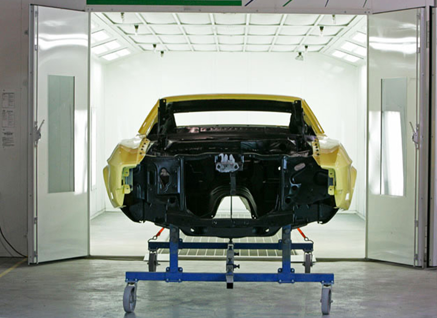 Yellow body of a car getting ready to go into the paint booth