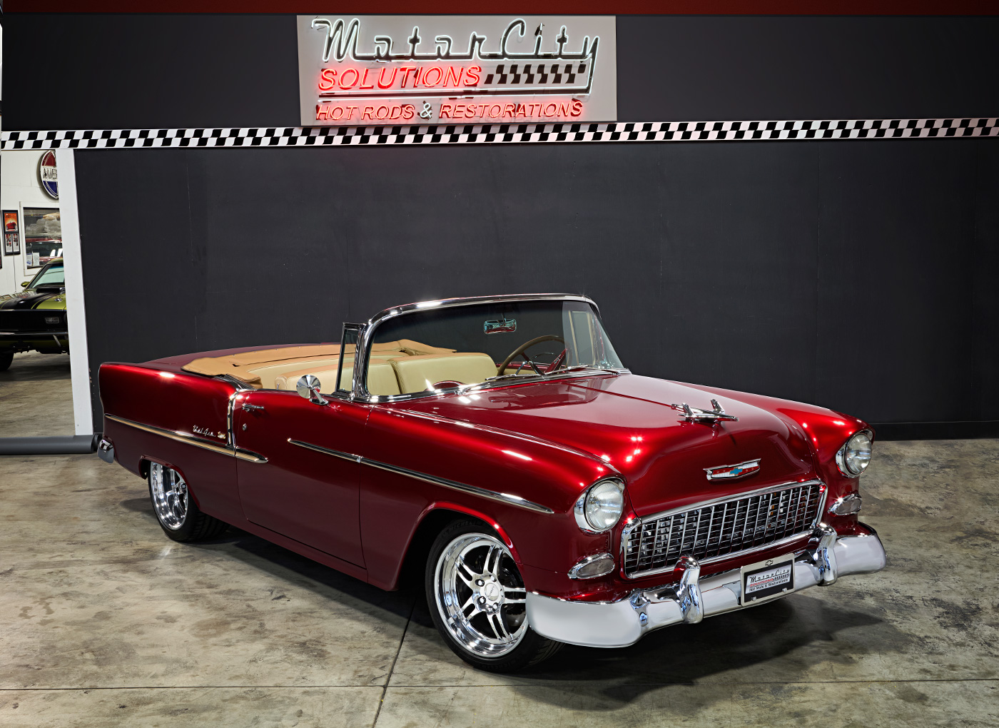 Red classic car inside the shop with a led sign above for Motor City Solutions Hot Rods & Restorations
